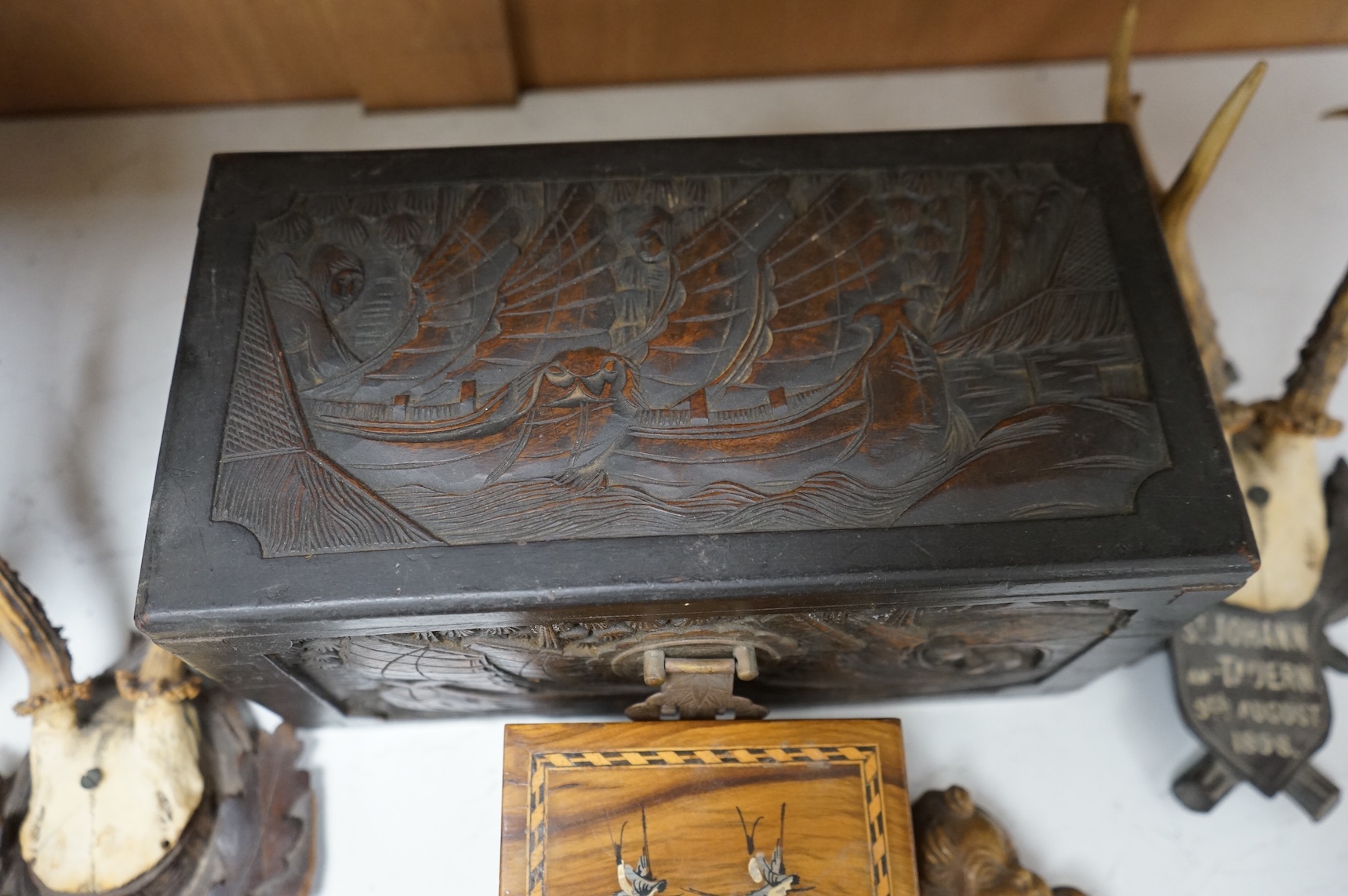 A Chinese carved wood box, two pairs of mounted deer horns, two carved wood cherub heads, an ashtray and an olivewood box, large box 29.5cm x 15cm high. (7)